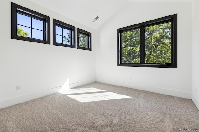 unfurnished room with light colored carpet and lofted ceiling