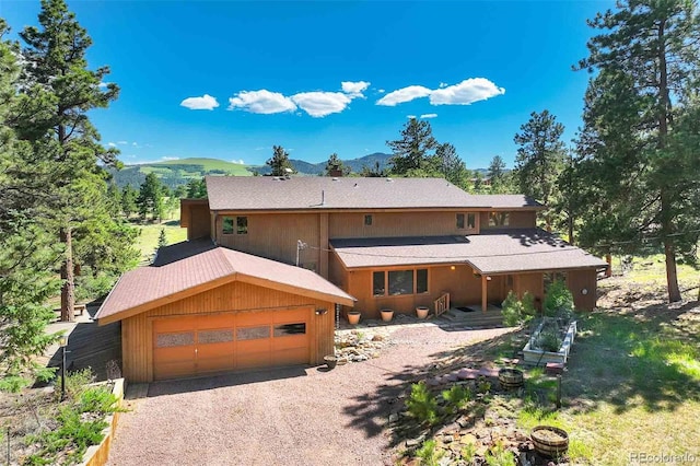 view of front of home with a garage and a mountain view