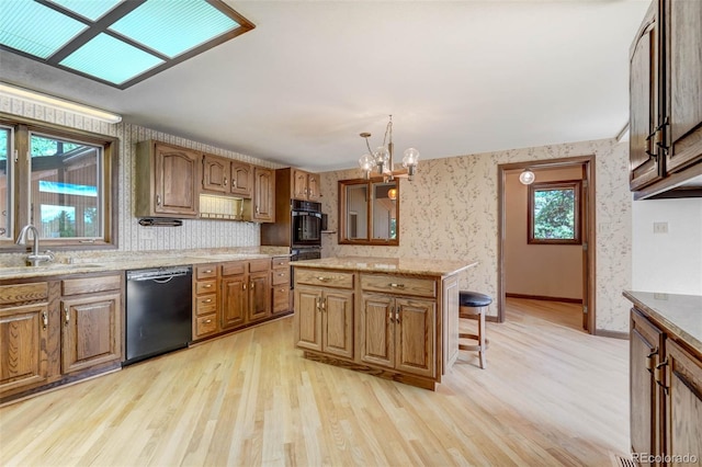 kitchen with black appliances, sink, and light wood-type flooring