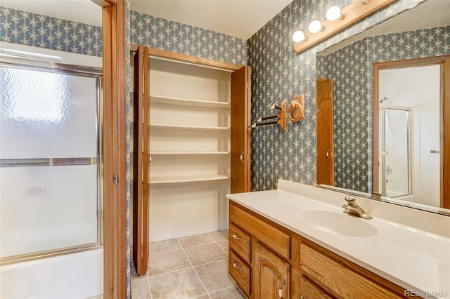 bathroom featuring vanity, tile patterned flooring, and enclosed tub / shower combo