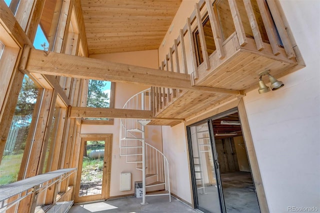 stairway featuring concrete floors and high vaulted ceiling