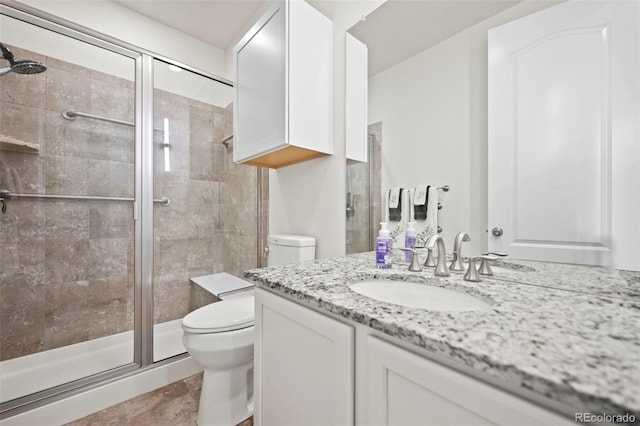 bathroom featuring vanity, toilet, an enclosed shower, and tile patterned floors