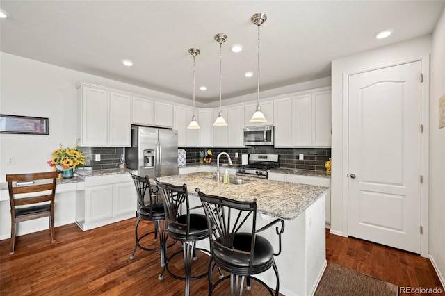 kitchen featuring dark wood-type flooring, decorative light fixtures, stainless steel appliances, and decorative backsplash