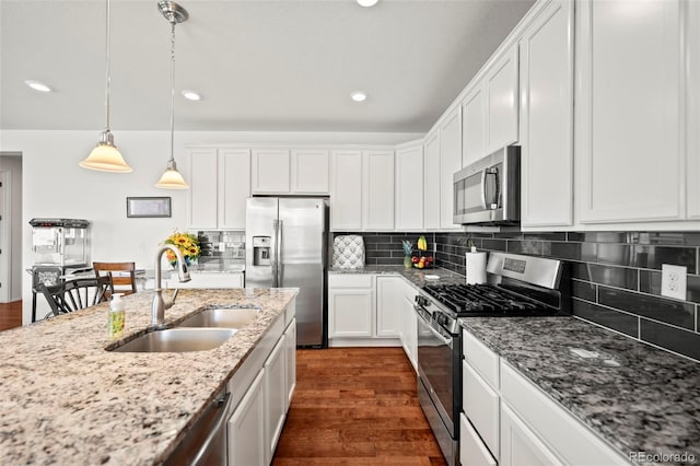 kitchen with white cabinets, backsplash, appliances with stainless steel finishes, sink, and dark hardwood / wood-style floors