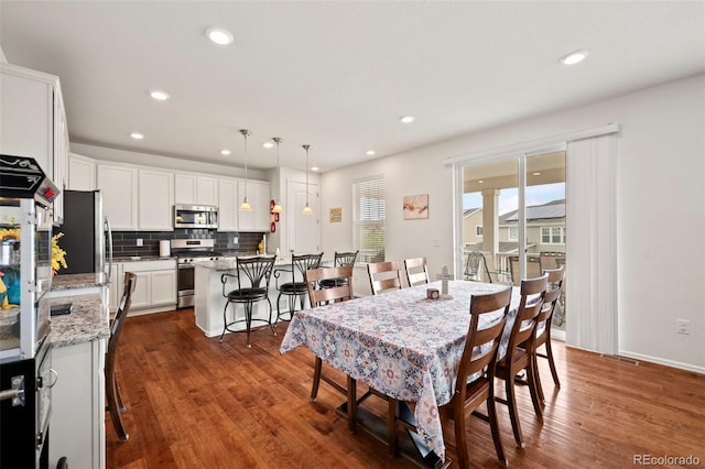 dining space with dark hardwood / wood-style flooring