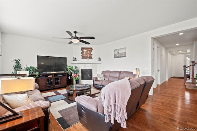 living room with ceiling fan, hardwood / wood-style flooring, and a fireplace