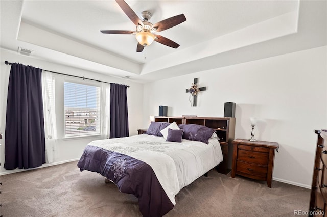 bedroom with ceiling fan, a raised ceiling, and carpet floors