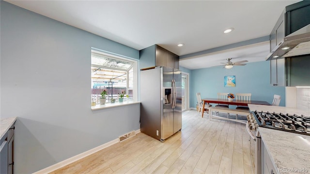 8774 Princeton St, Westminster, CO 80031 - kitchen featuring appliances with stainless steel finishes, wall chimney exhaust hood, ceiling fan, baseboards, and light wood-style flooring
