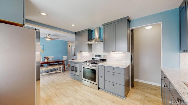 8774 Princeton St, Westminster, CO 80031 - kitchen with wall chimney range hood, appliances with stainless steel finishes, ceiling fan, gray cabinetry, and decorative backsplash