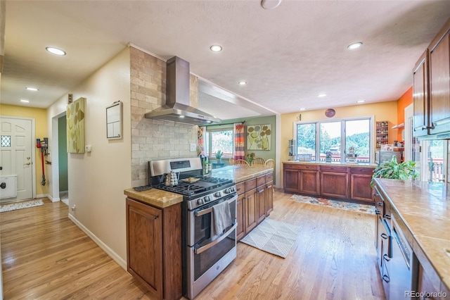 570 Columbine Ave, Golden, CO 80401 - kitchen featuring double oven range, wall chimney exhaust hood, light wood finished floors, light countertops, and recessed lighting