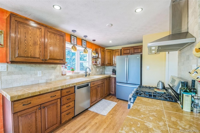 570 Columbine Ave, Golden, CO 80401 - kitchen featuring wall chimney exhaust hood, appliances with stainless steel finishes, brown cabinetry, and recessed lighting