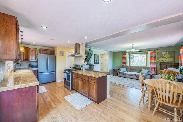 570 Columbine Ave, Golden, CO 80401 - kitchen with appliances with stainless steel finishes, wall chimney exhaust hood, light countertops, light wood-style flooring, and recessed lighting
