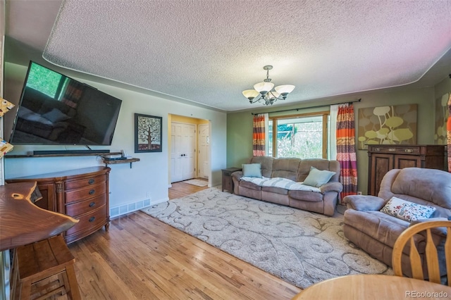 570 Columbine Ave, Golden, CO 80401 - living room featuring a textured ceiling, wood finished floors, and a chandelier