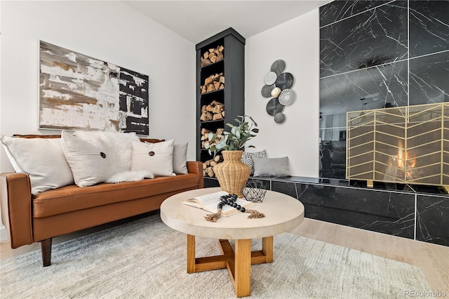 sitting room featuring wood-type flooring and a premium fireplace