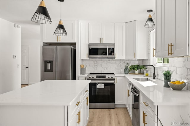 kitchen with white cabinetry, light stone countertops, pendant lighting, and stainless steel appliances