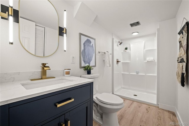 bathroom with toilet, vanity, a shower, and hardwood / wood-style floors