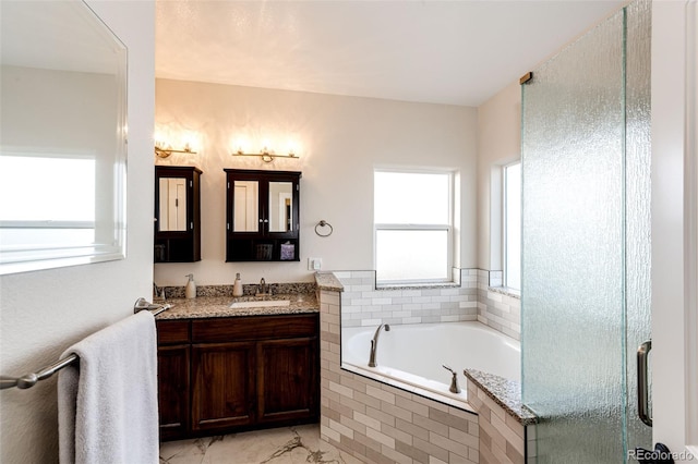 bathroom with a garden tub and vanity