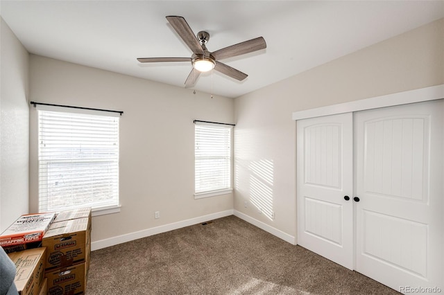 carpeted bedroom featuring a closet, a ceiling fan, and baseboards