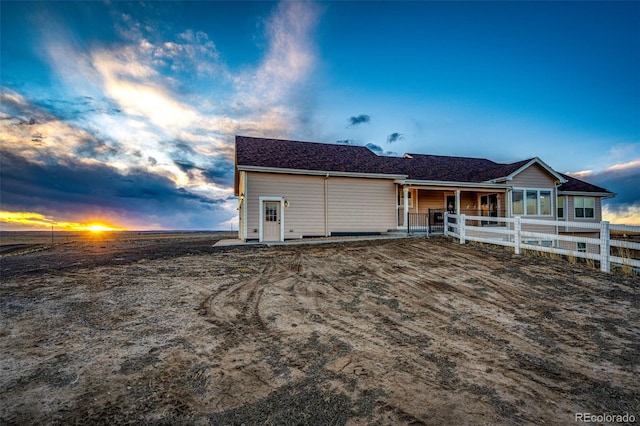 ranch-style house featuring fence