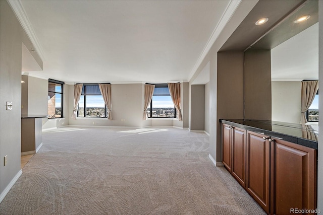 hall with crown molding, baseboards, and light colored carpet