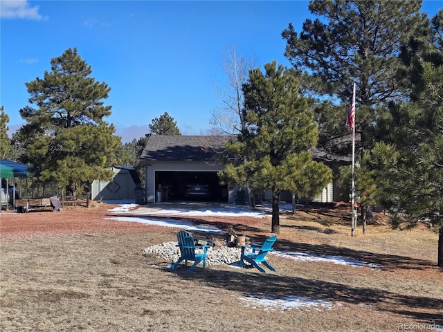 exterior space with a garage and a fire pit