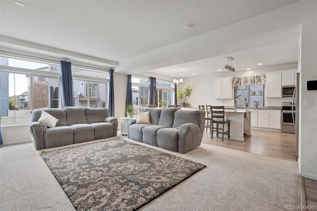 carpeted living room featuring a chandelier