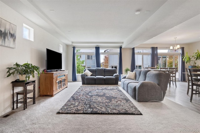 carpeted living room with a chandelier