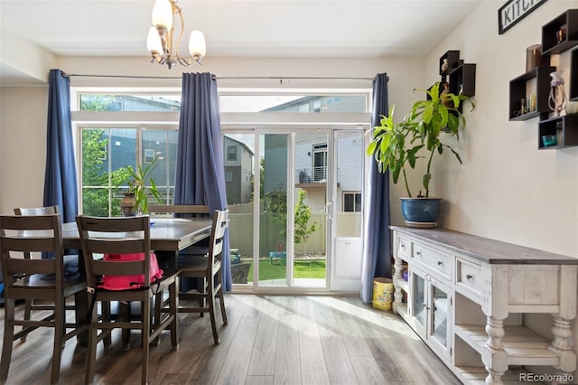 interior space with wood-type flooring, a wealth of natural light, and an inviting chandelier