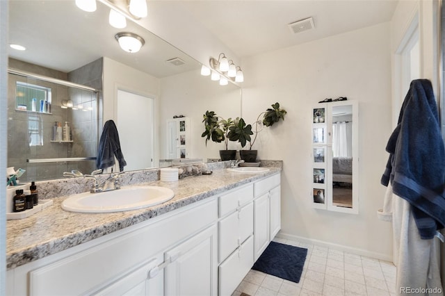 bathroom featuring tile patterned floors, a shower with shower door, and vanity