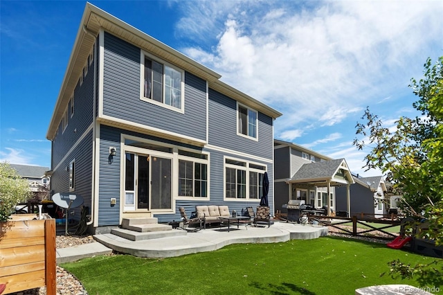 back of house featuring a lawn, an outdoor living space, and a patio area