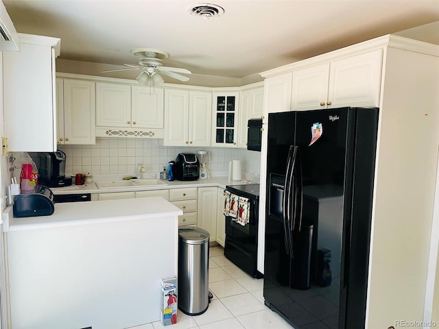 kitchen featuring black appliances, white cabinets, light tile patterned floors, and sink