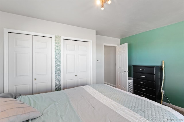 bedroom featuring two closets and baseboards