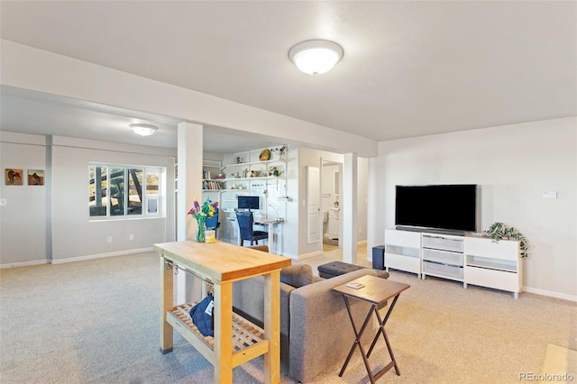 living area featuring baseboards and light colored carpet