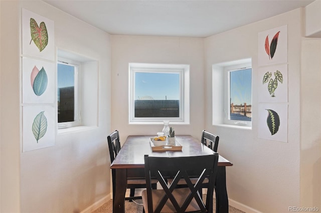 dining space with carpet floors and baseboards