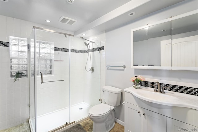 full bath with vanity, a stall shower, backsplash, and toilet