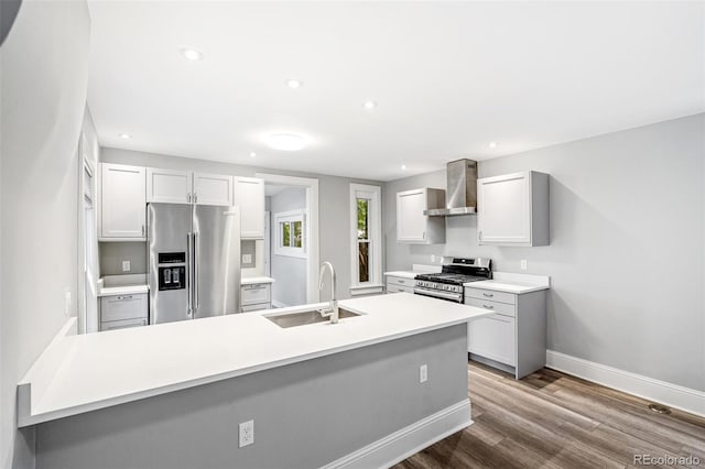 269 Delaware St, Denver, CO 80223 - kitchen featuring stainless steel appliances, wall chimney range hood, dark wood finished floors, light countertops, and recessed lighting