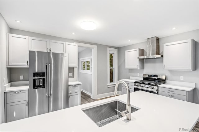 269 Delaware St, Denver, CO 80223 - kitchen featuring stainless steel appliances, wall chimney exhaust hood, light countertops, dark wood-type flooring, and recessed lighting