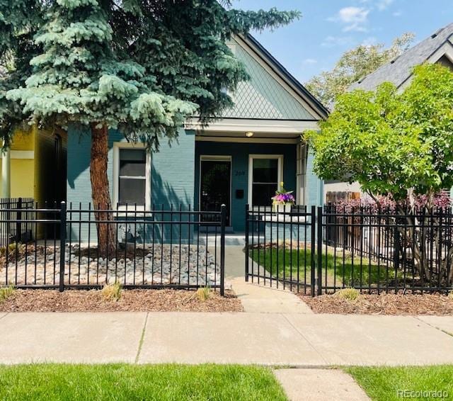 269 Delaware St, Denver, CO 80223 - view of front facade with covered porch and a fenced front yard