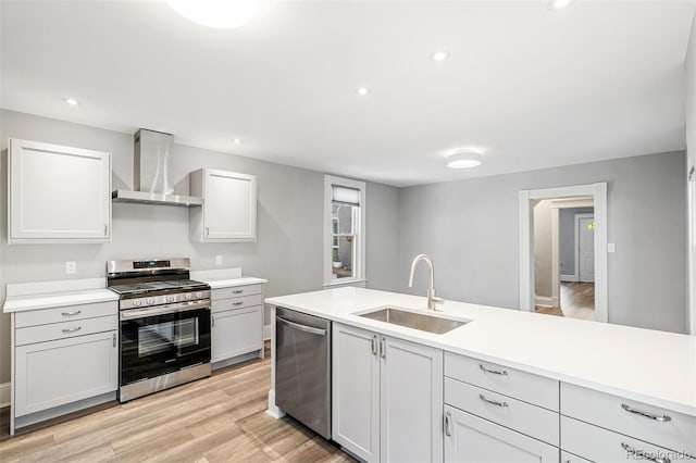 269 Delaware St, Denver, CO 80223 - kitchen with appliances with stainless steel finishes, wall chimney exhaust hood, light wood finished floors, light countertops, and recessed lighting