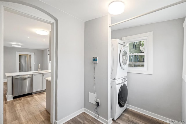 269 Delaware St, Denver, CO 80223 - washroom featuring stacked washer / dryer and light wood-type flooring