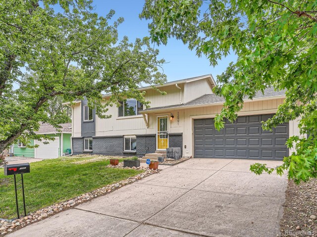 12991 E Idaho Dr, Aurora, CO 80012 - tri-level home featuring an attached garage, concrete driveway, a front lawn, and brick siding