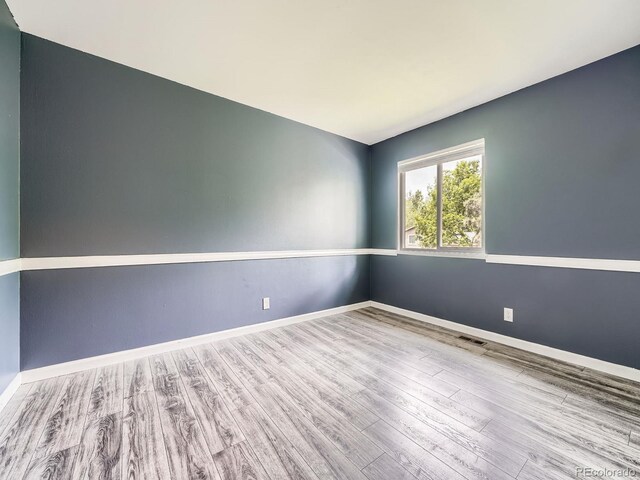12991 E Idaho Dr, Aurora, CO 80012 - empty room featuring wood finished floors and baseboards