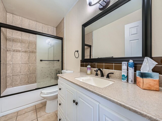12991 E Idaho Dr, Aurora, CO 80012 - bathroom with toilet, tile patterned flooring, vanity, and shower / bath combination with glass door