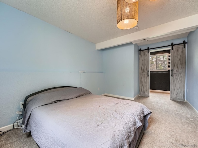 12991 E Idaho Dr, Aurora, CO 80012 - carpeted bedroom with a textured ceiling, baseboards, and a barn door