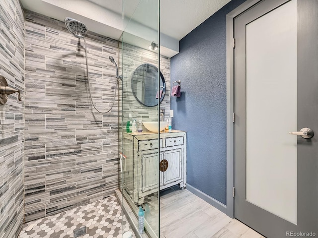 12991 E Idaho Dr, Aurora, CO 80012 - full bath featuring tiled shower, a textured wall, and vanity