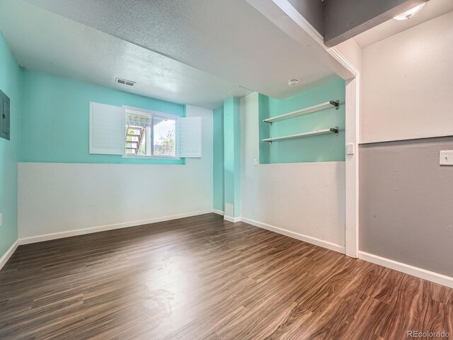 12991 E Idaho Dr, Aurora, CO 80012 - empty room featuring wood finished floors, baseboards, electric panel, and a textured ceiling