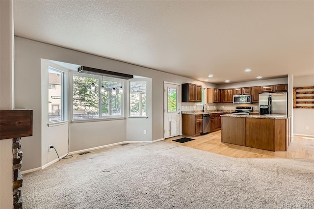 13018 Niagara Way, Thornton, CO 80602 - kitchen featuring appliances with stainless steel finishes, light colored carpet, baseboards, recessed lighting, and a center island
