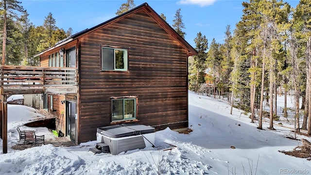 view of snowy exterior featuring log veneer siding