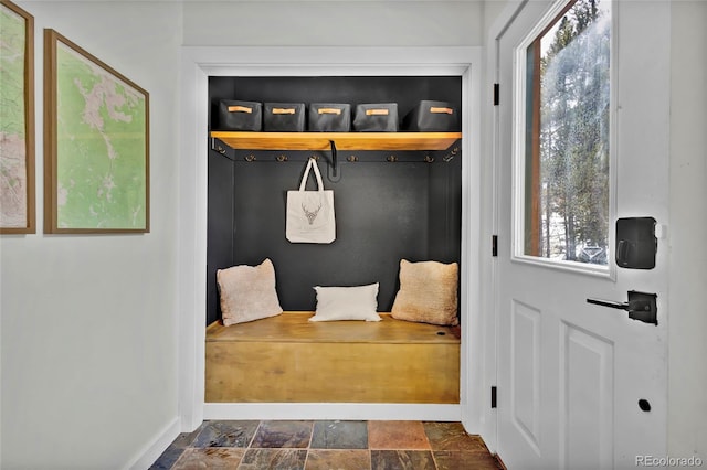 mudroom with stone finish flooring and baseboards