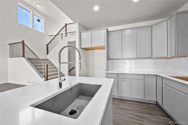 kitchen featuring gray cabinets, light countertops, and a sink